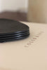 Hochwertige schwarze Lederuntersetzer im Soft-Minimal-Living-Stil, auf Konsole platziert, mit Cappuccino-Becher