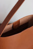Detail des Magnetverschlusses an der braunen Ledertasche