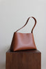 Seitenansicht der braunen Ledertasche mit ihrer leicht zulaufenden Form
