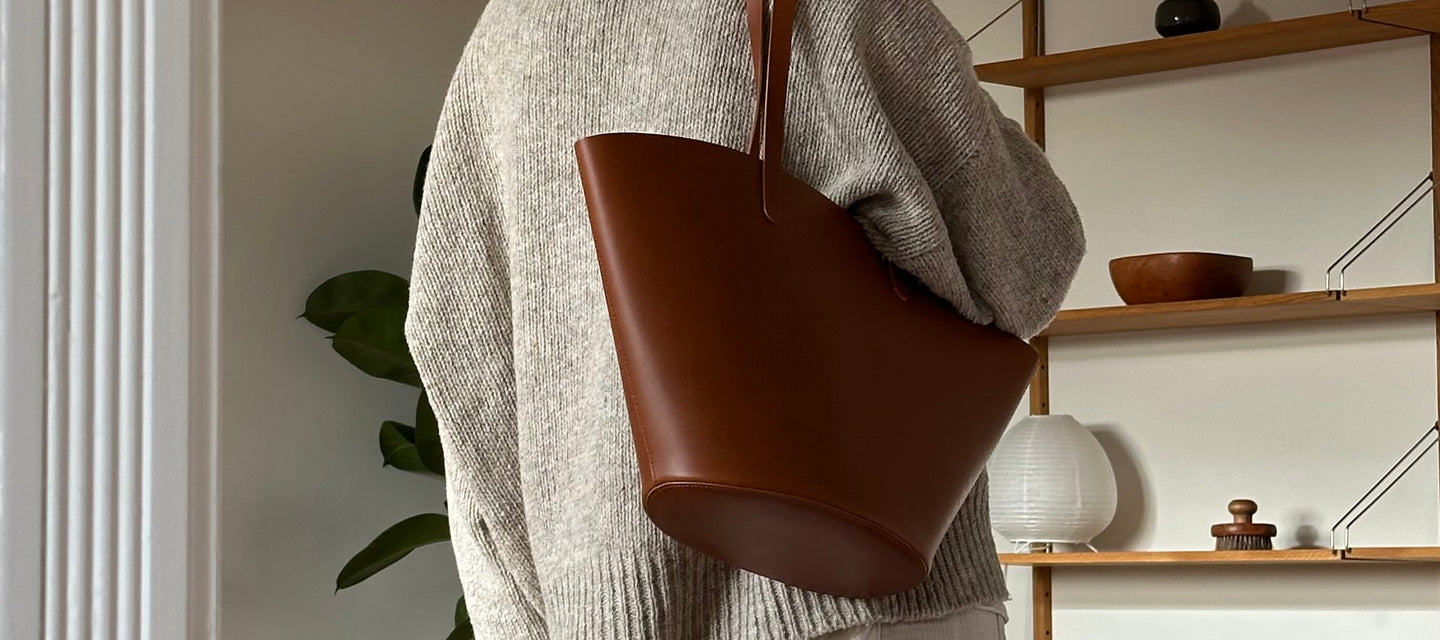 Handgefertigte Ledertasche aus pflanzlich gegerbtem Leder von Sjaelv Studio, getragen in einem natürlichen Wohnambiente.