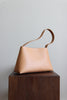 Seitenansicht der naturfarbenen Ledertasche mit leicht zulaufender Form