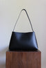 Schwarze Shoulder Bag aus pflanzlich gegerbtem Leder mit Schulterriemen in der Frontansicht.